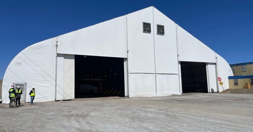 Carpa PVC de gran tamaño instalada por Tecno Fast en faena minera, con trabajadores en terreno.